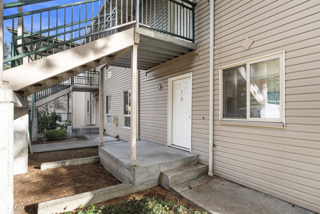 the front of a house with stairs and a white door