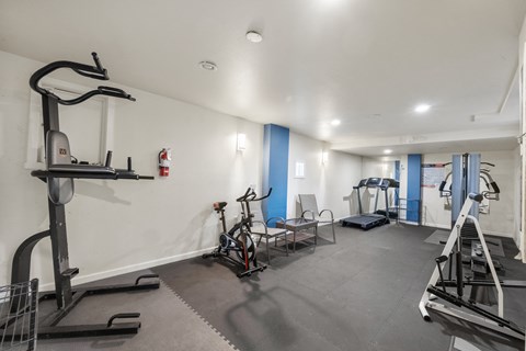 a gym with weights and exercise equipment in a room with white walls