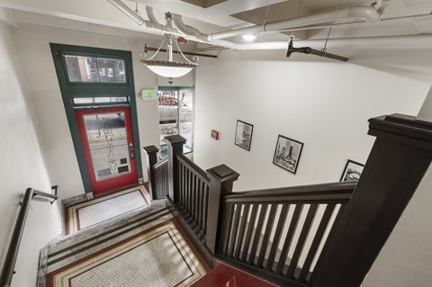 A staircase with a chandelier hanging from the ceiling.