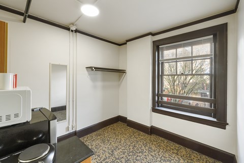 A kitchen with a microwave, oven, and a window.
