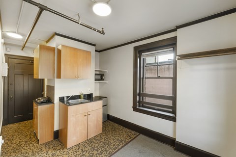 A kitchen area with wooden cabinets and a black countertop.