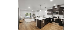 A modern kitchen with dark brown cabinets and stainless steel appliances.
