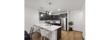 A modern kitchen with a white table and black cabinets.