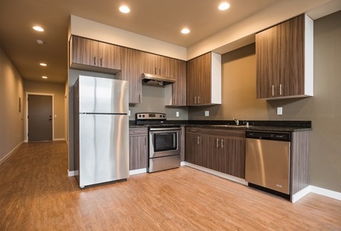 A modern kitchen with wooden cabinets and stainless steel appliances.