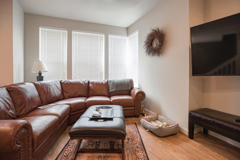 A living room with a brown leather couch and a coffee table.