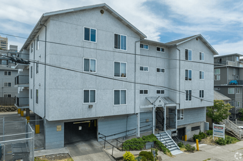 A large white building with a garage door and stairs leading to the entrance.