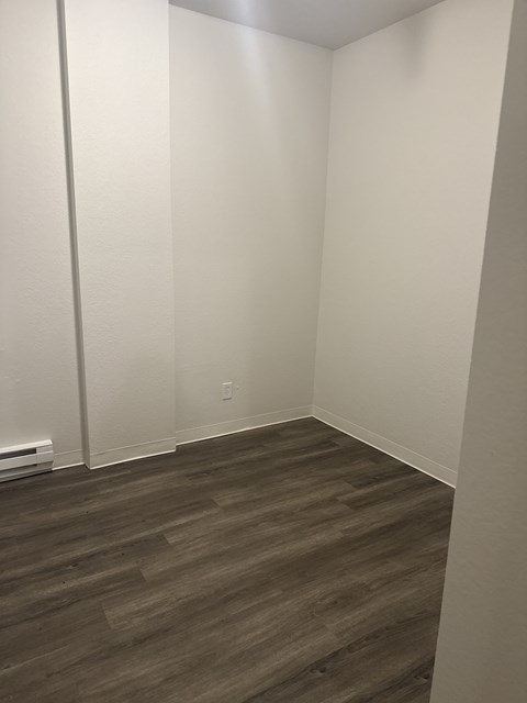 A room with a wooden floor and white walls.