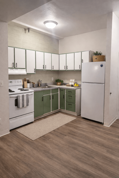A kitchen with white cabinets and a white refrigerator.