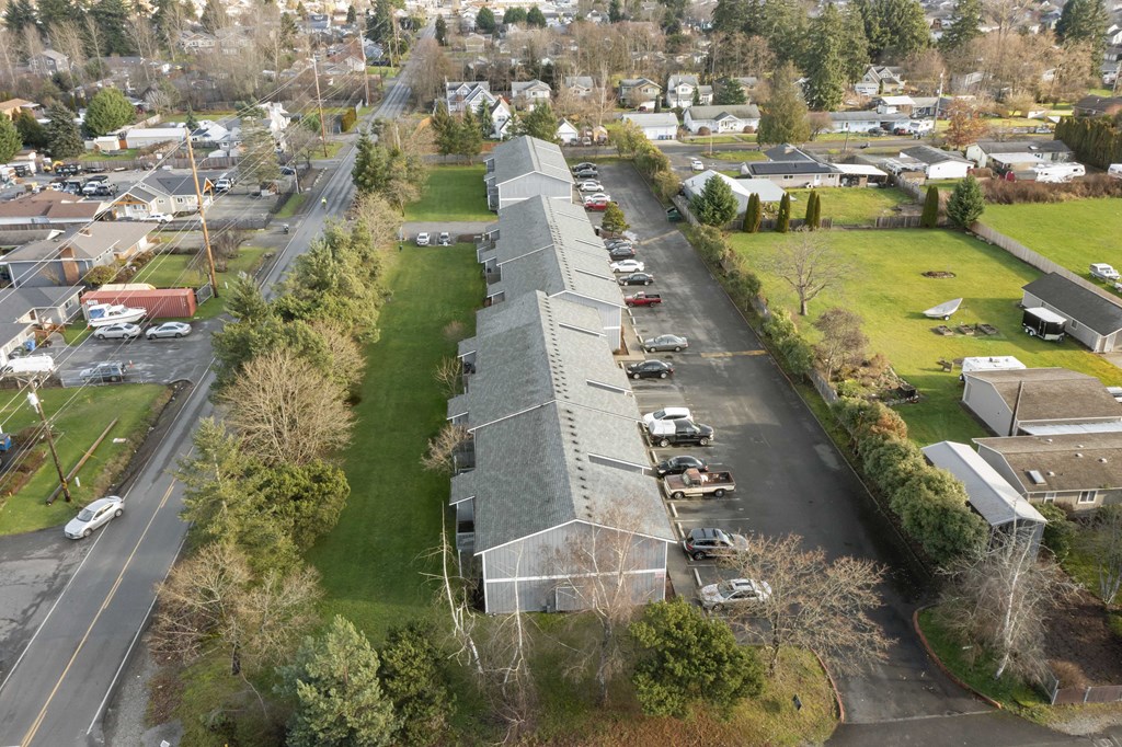 an aerial view of a building with cars parked in a parking lot
