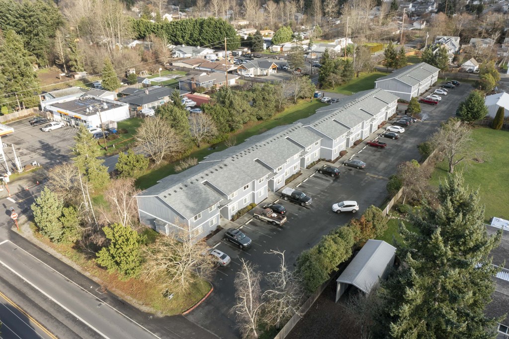 an aerial view of a building with cars parked in a parking lot