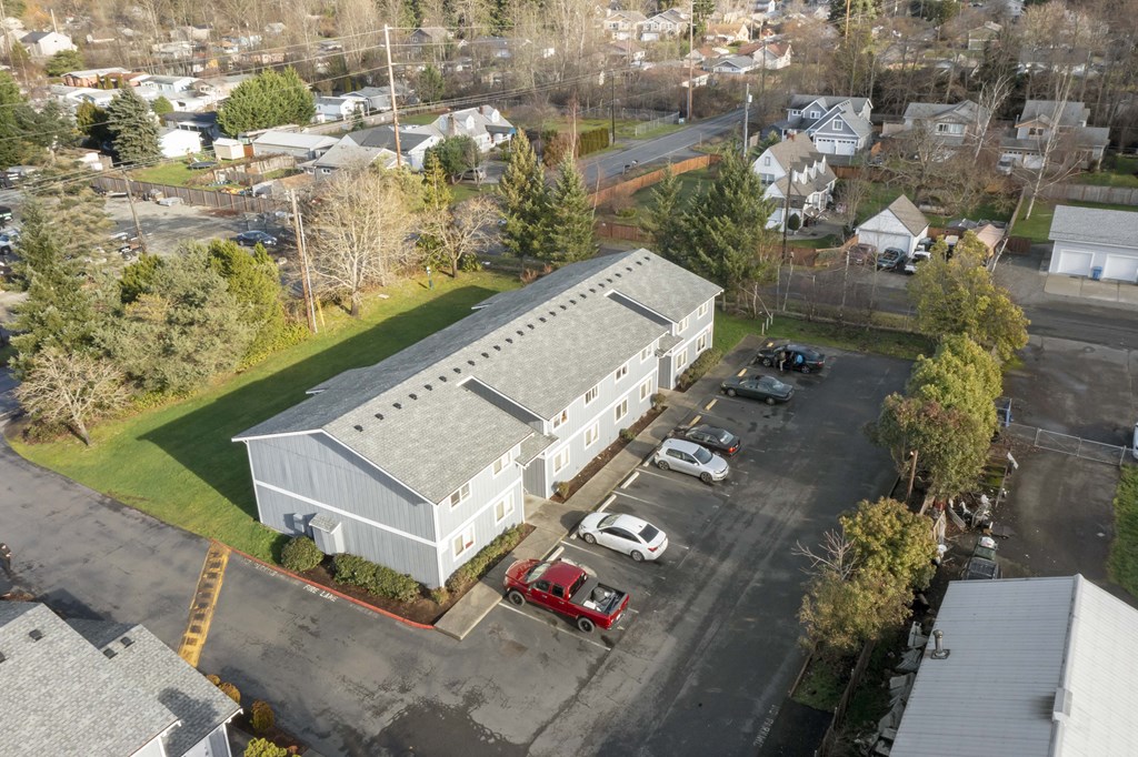 an aerial view of a white building with a gray roof
