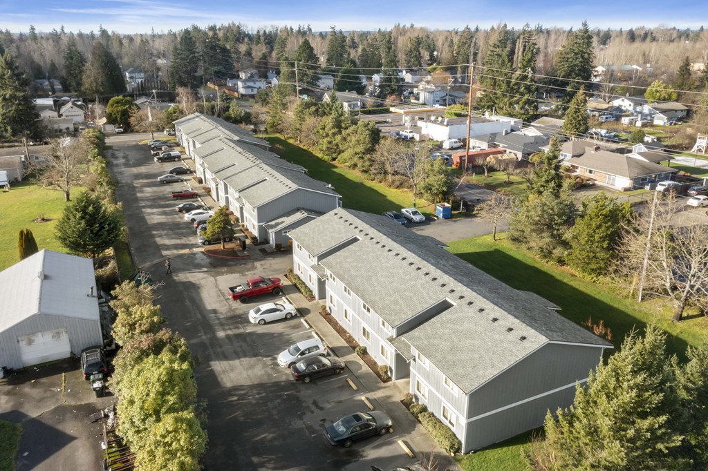an aerial view of a building with cars parked in a parking lot