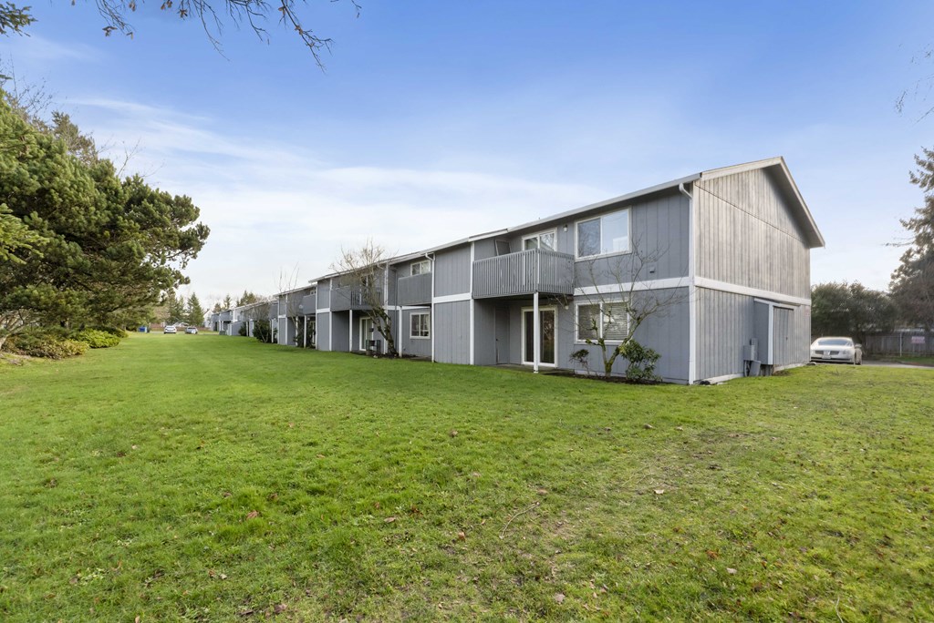 a row of apartment buildings on a green field