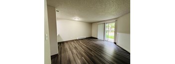 A room with wooden flooring and a sliding glass door.