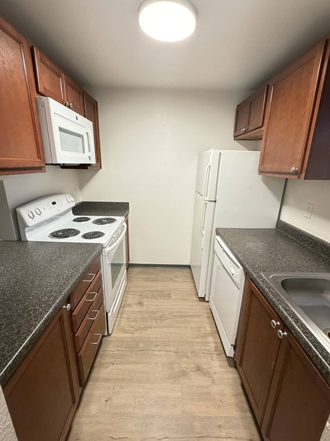 A kitchen with brown cabinets and a white stove top oven.