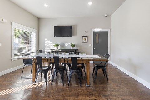 Meeting room with large table and chairs and tv mounted on wall