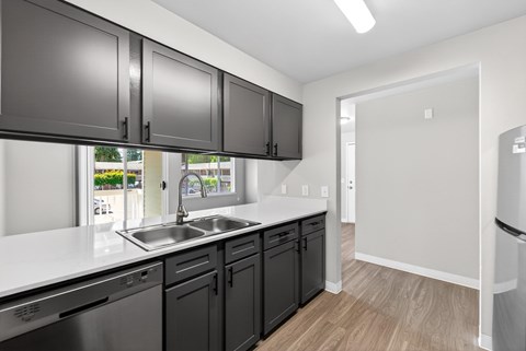 A kitchen with black cabinets and a white countertop.