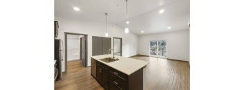 A kitchen with dark wood cabinets and a white countertop.