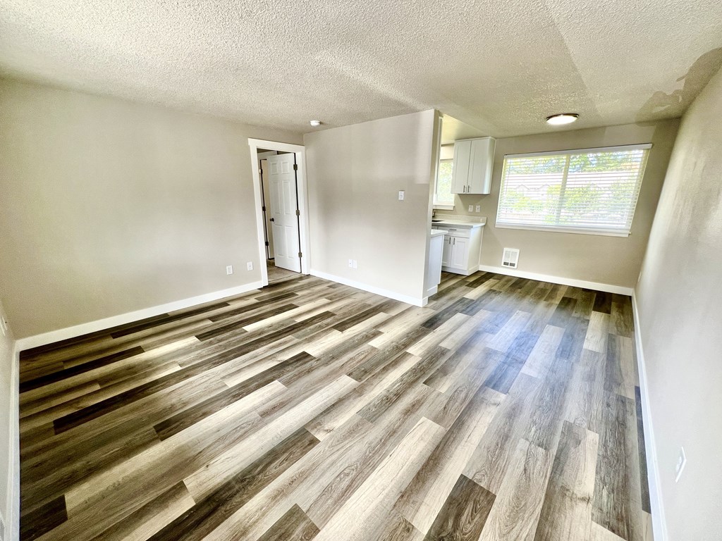 A room with wooden flooring and a white door.