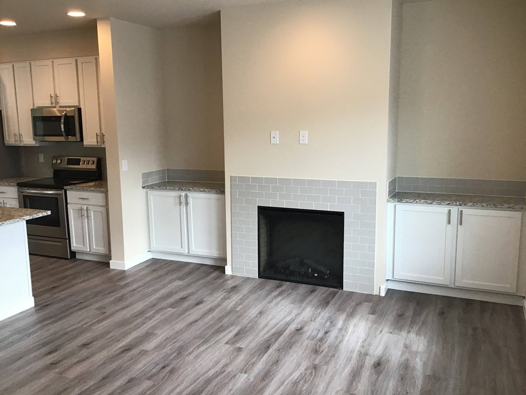 a renovated living room with white cabinets and a fireplace