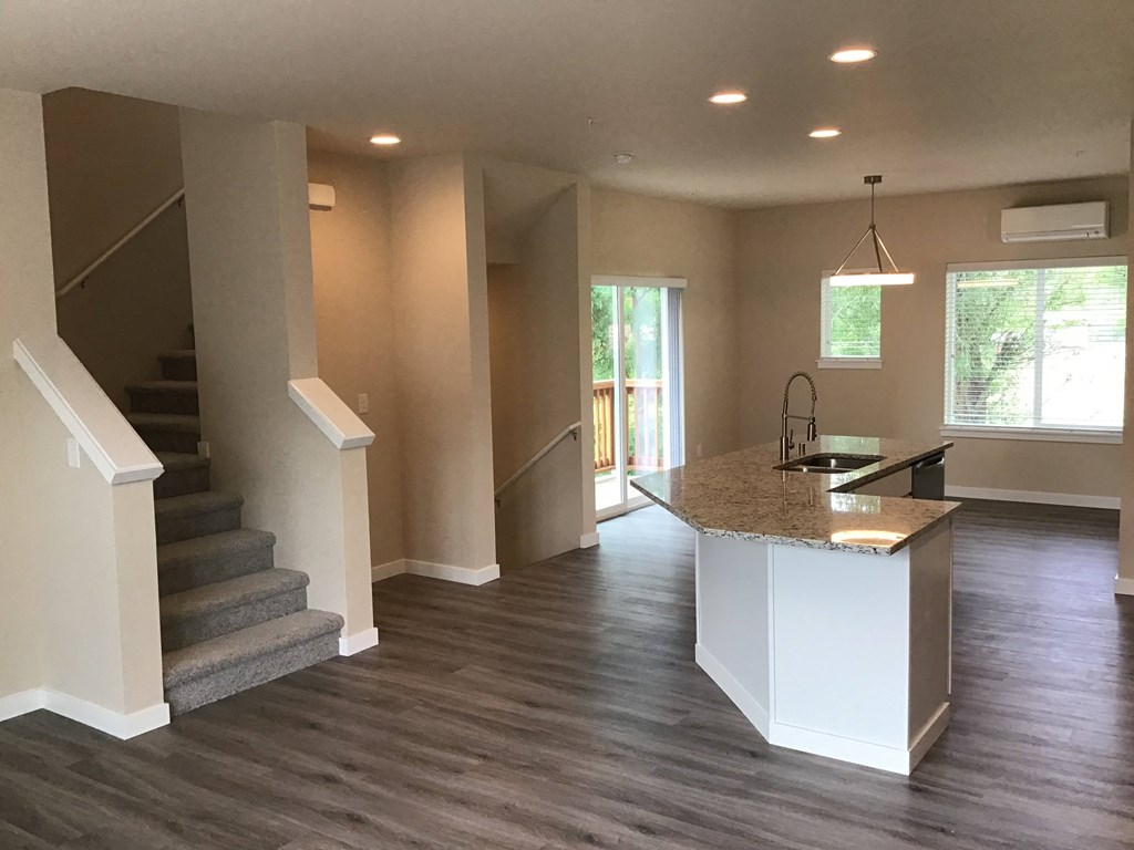 a view of a living room with a staircase and a kitchen