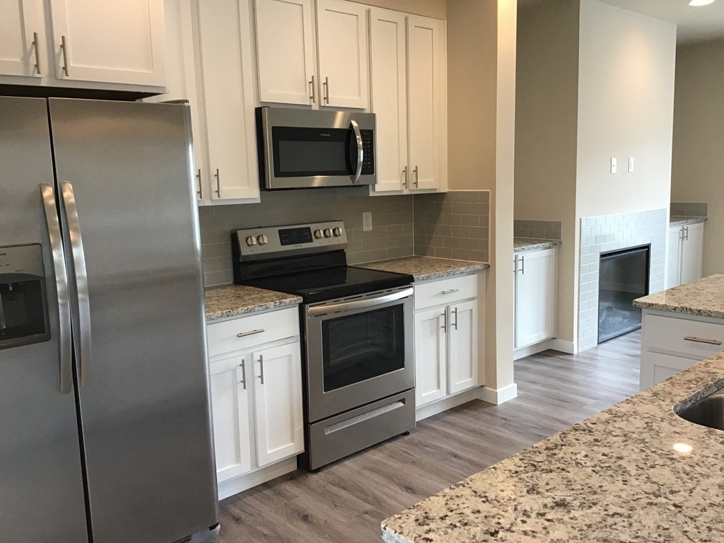 a kitchen with stainless steel appliances and white cabinets