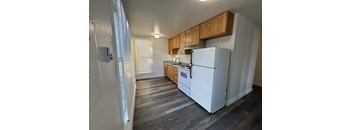 A kitchen with a white refrigerator and wooden cabinets.