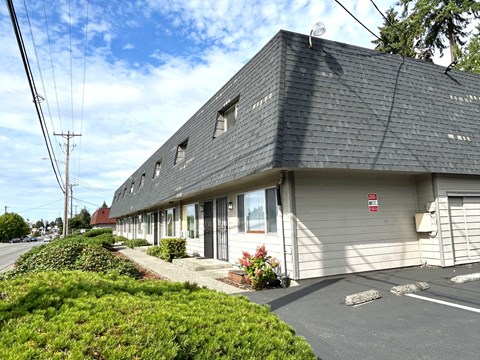 A building with a grey roof and a red sign on the side.