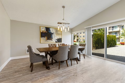 A dining room with a wooden table and chairs.