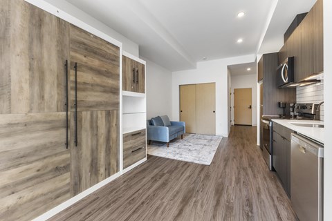 A modern kitchen with wooden floors and cabinets.