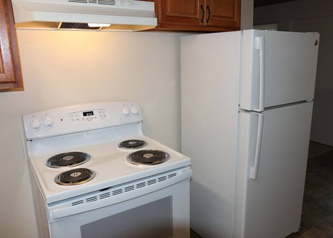 A white stove and refrigerator in a kitchen.
