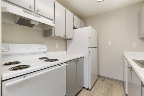 A kitchen with white appliances and cabinets.