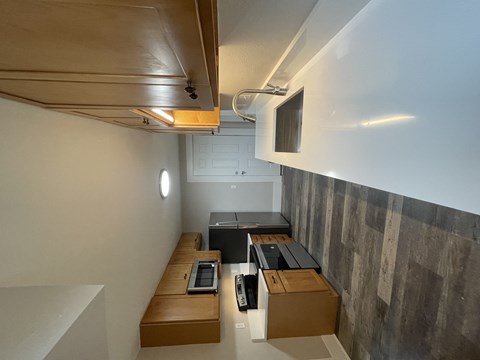 A room with a brown bench and a black printer on it.