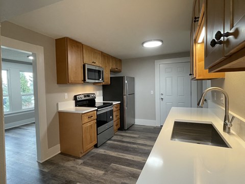 A kitchen with a white counter top and a black refrigerator.