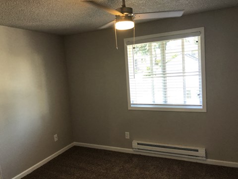 a living room with a ceiling fan and a window