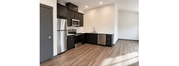 A modern kitchen with dark wood cabinets and stainless steel appliances.