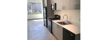 A kitchen with a sink, dishwasher, and refrigerator.