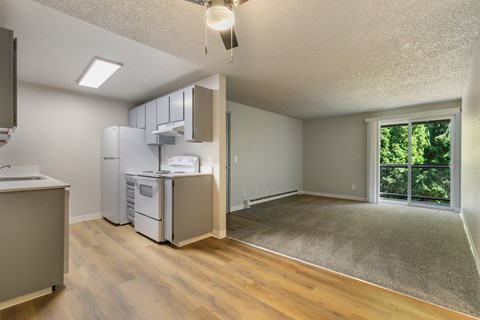 A kitchen with a refrigerator, microwave, and oven.