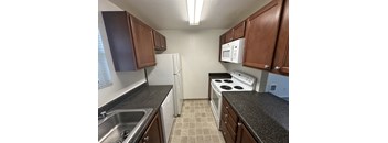 a kitchen with granite counter tops and a white stove and refrigerator