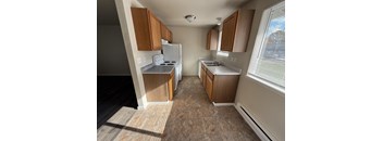 A kitchen with wooden cabinets and a white refrigerator.
