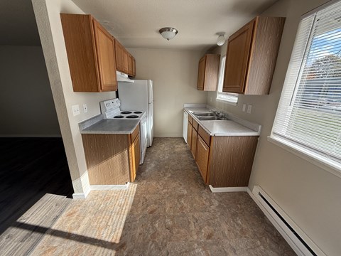 A kitchen with wooden cabinets and a white refrigerator.