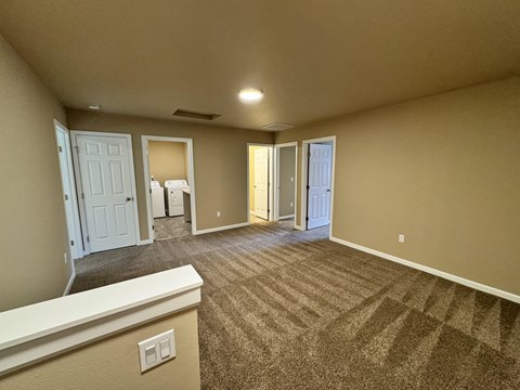 A spacious room with carpeted floor and white trim.