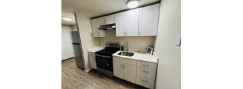 A kitchen with white cabinets and a black stove top oven.