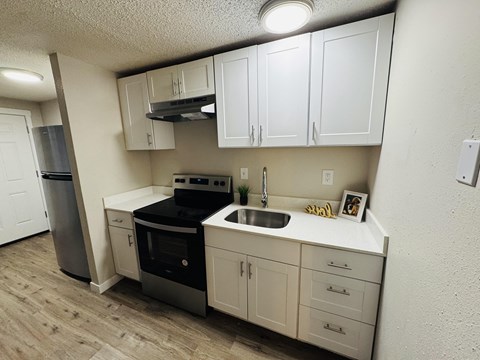 A kitchen with white cabinets and a black stove top oven.