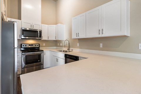 a kitchen with white counter tops and stainless steel appliances