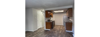 an empty kitchen with wood flooring and stainless steel appliances