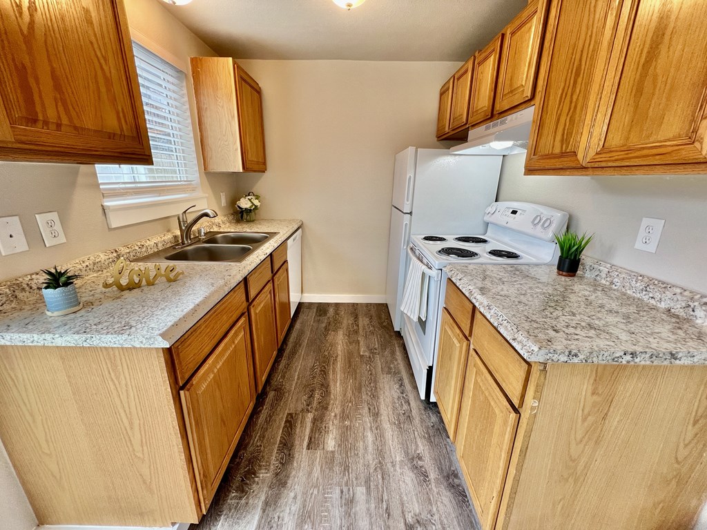 A kitchen with wooden cabinets and a white fridge.