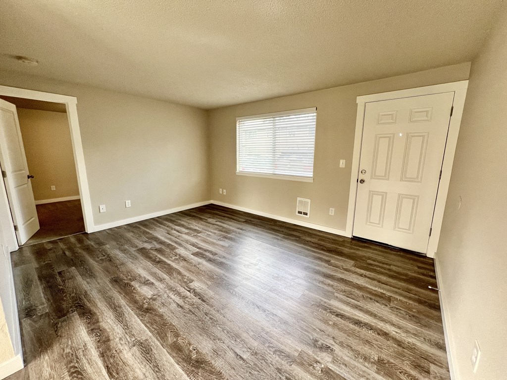 A room with a wooden floor and white walls.