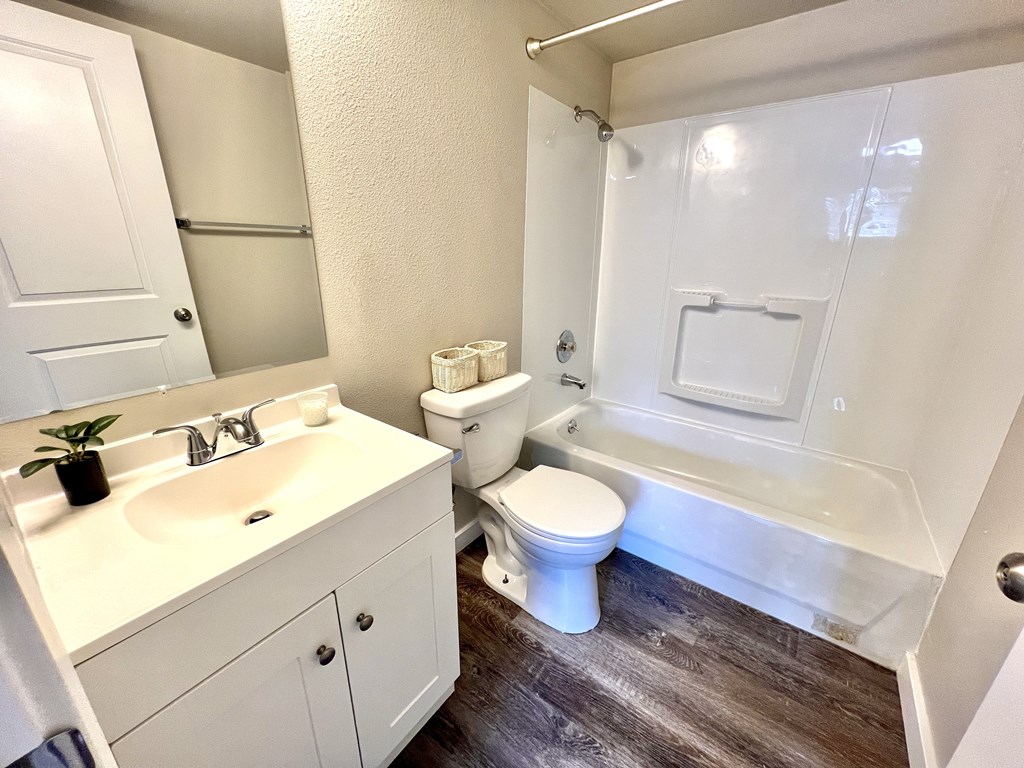 A white bathroom with a toilet, sink, and bathtub.