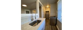 A kitchen with a sink and a refrigerator.